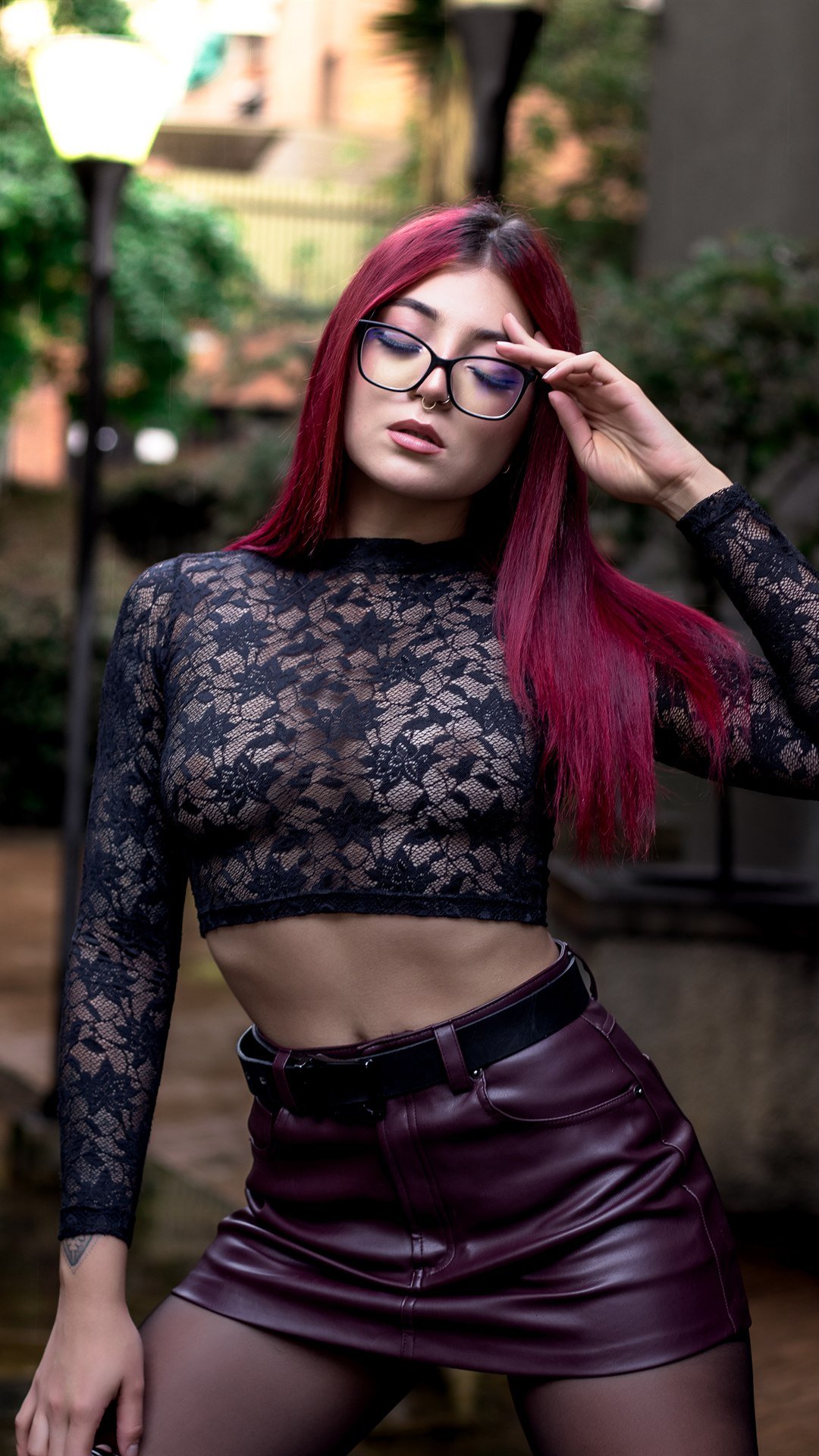 Retrato en una calle de noche, con top de encaje y falda de cuero