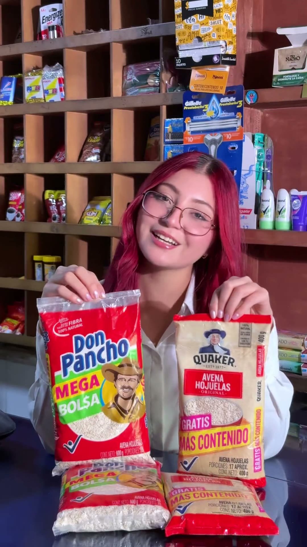 Sosteniendo en alto dos paquetes de producto en una tienda de barrio