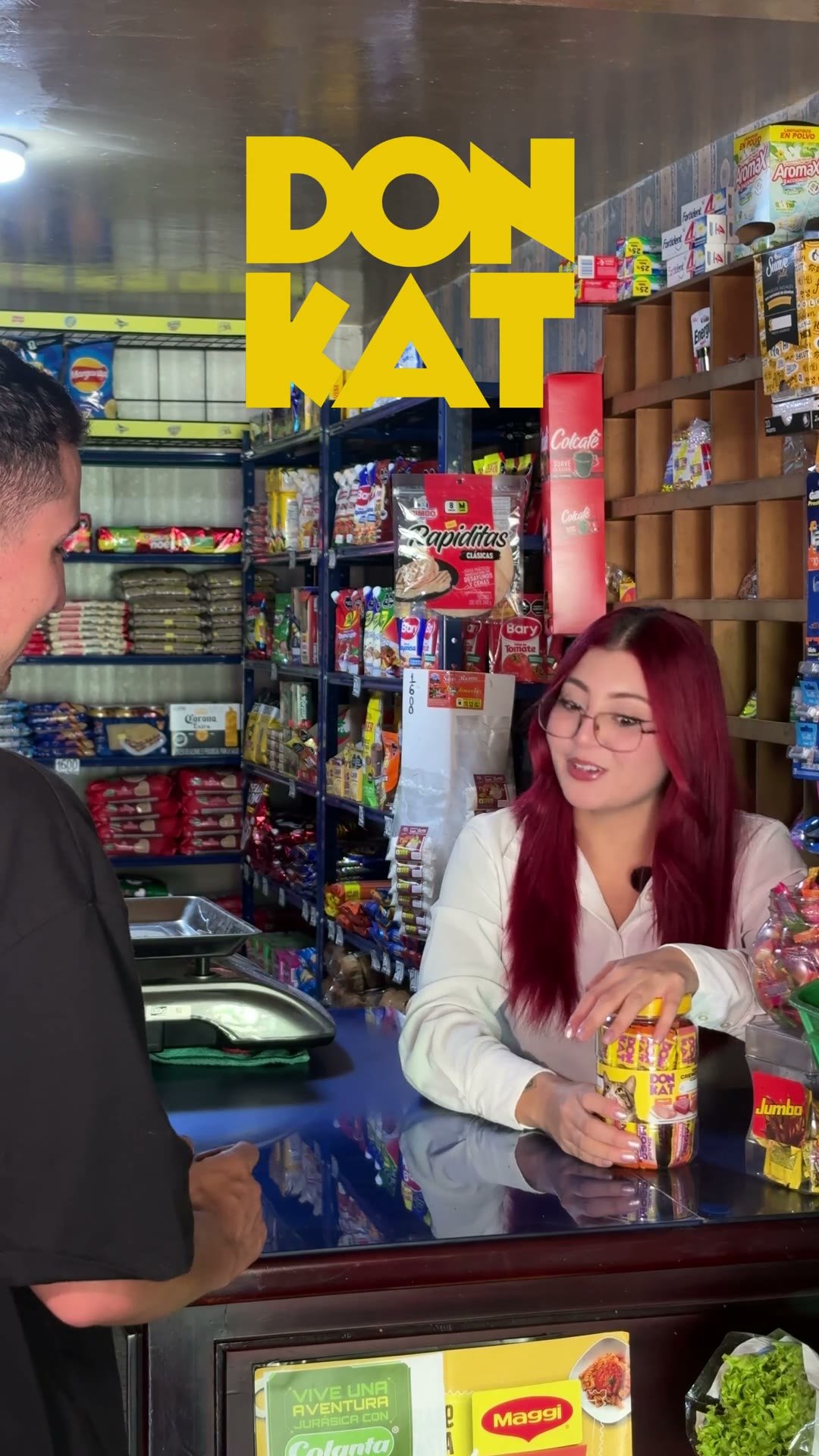 Atendiendo el mostrador de una tienda de barrio, con el rótulo de la marca sobre la escena